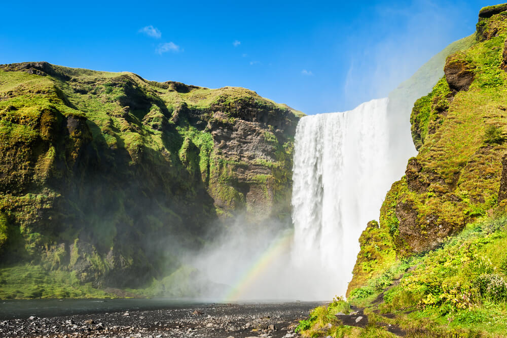 La chute d'eau de Skógafoss, en été dans une décor verdoyant ©Shutterstock