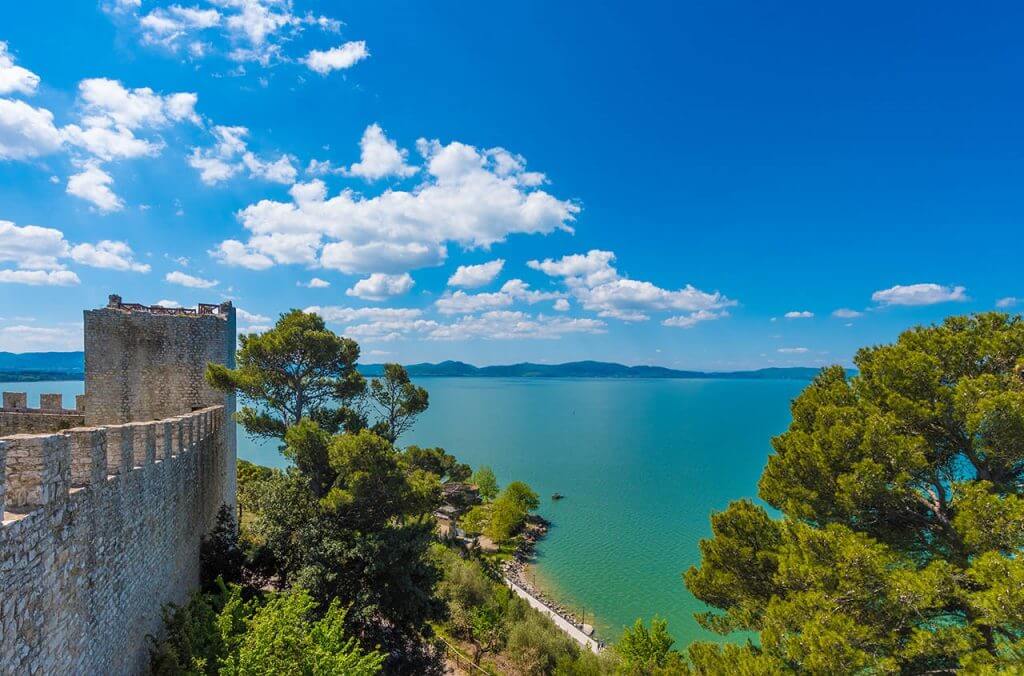 Le lac de Trasimène et le château du village Castiglione del Lago ©bluebayperugia